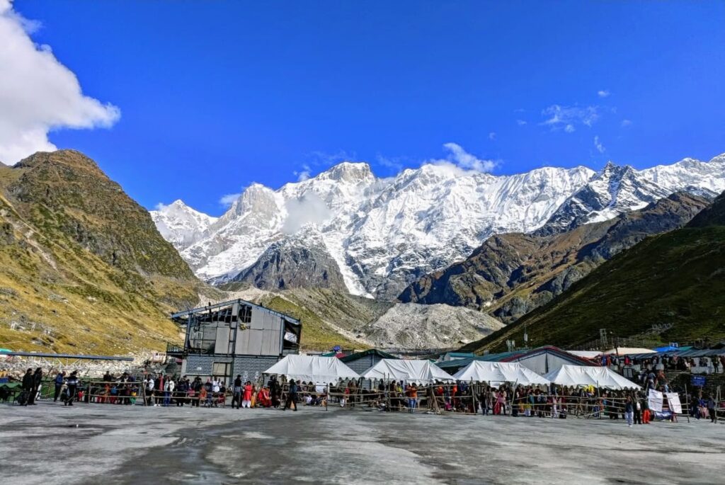 A group of people standing in front of Chardham yatra mountains.